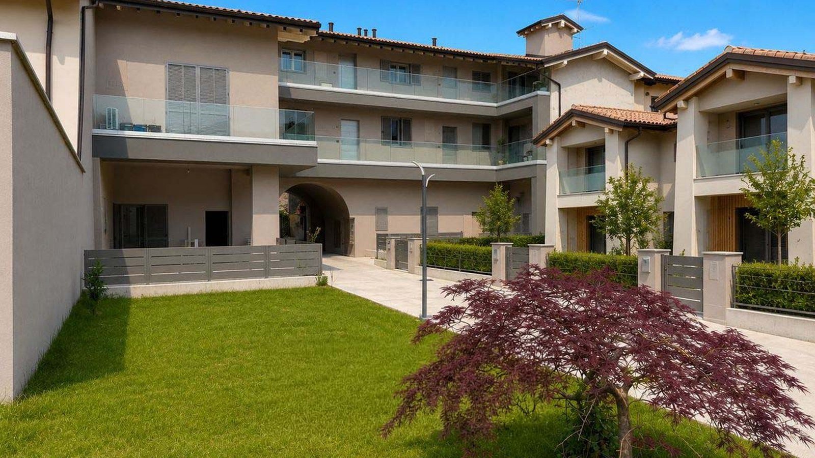 Trilocale al piano terra in Via Arici 35 a Telgate: la corte interna con prato, acero rosso e le unita affacciate sul verde
